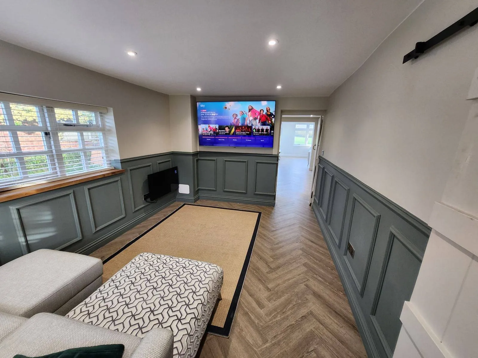 Whole-house renovation: living room with wall panelling and herringbone floor
